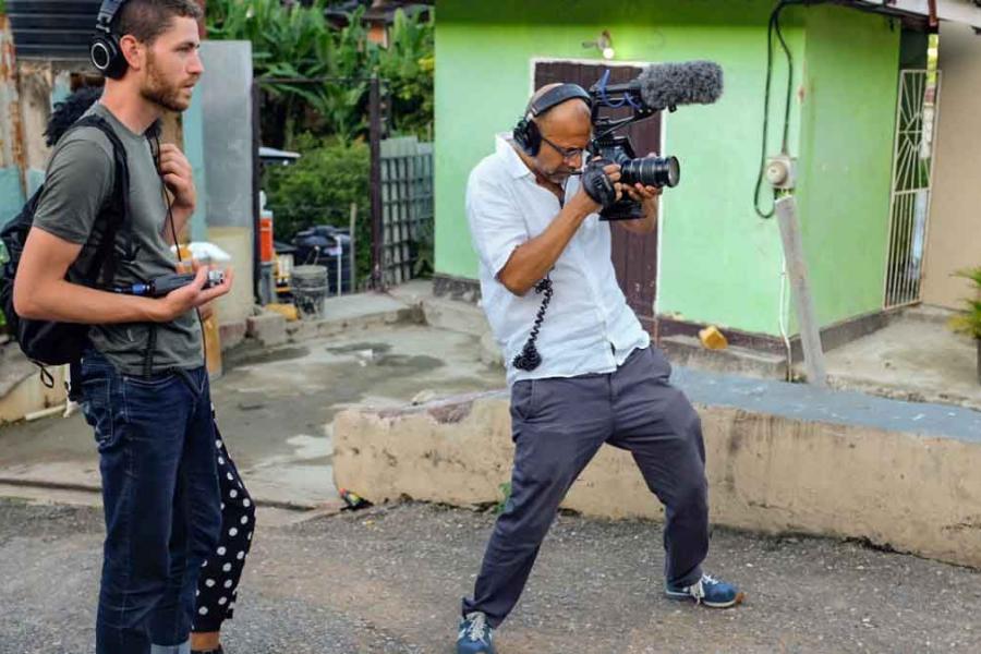 man with video camera and another man with headphones