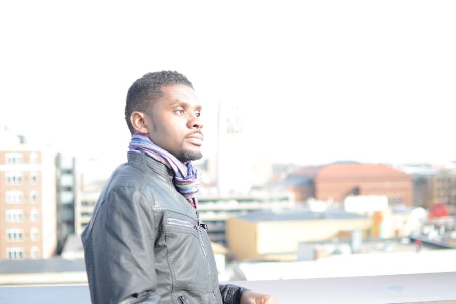 Person wearing a leather jacket, with a city scape in the background