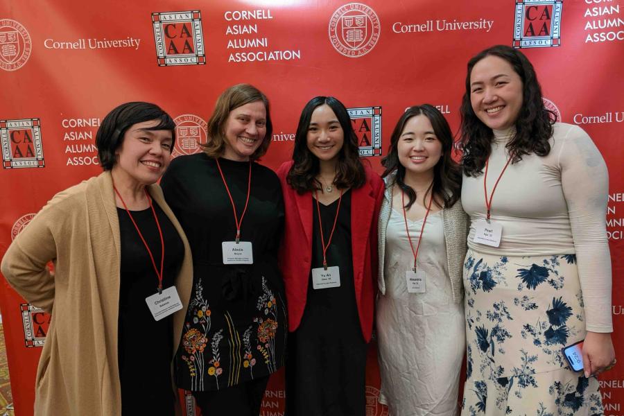 five women in front of red background