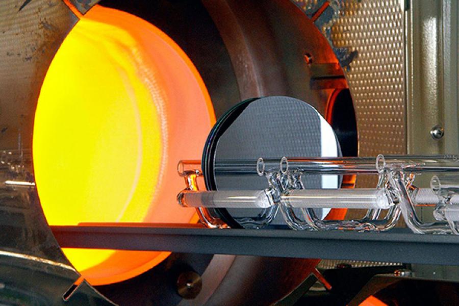 Glass on a tray, entering a glowing orange furnace