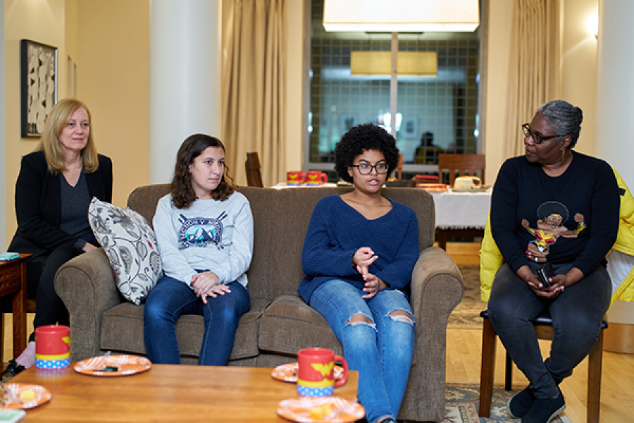  Students sitting on couch listening to a conversation.